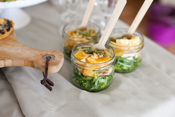gourmet salad in glass jars on buffet table