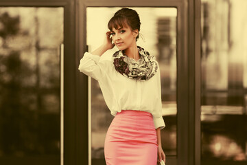 Young fashion business woman in white shirt and pencil skirt at office building
