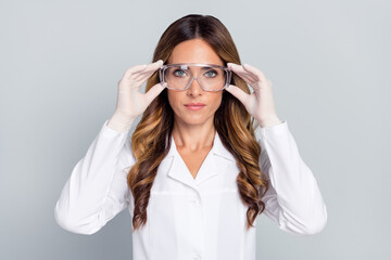 Portrait of attractive wavy-haired woman doc touching specs lab research isolated over grey pastel...