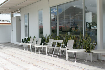 White chairs and tables were arranged in front of the glass room.