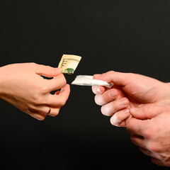 The drug dealer passes the white powder to the customer, the illicit distribution of the drug.