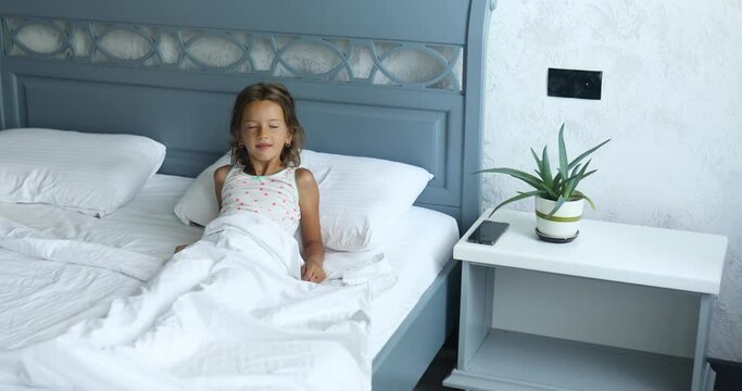 Little girl wakes up from sleep on a big and cozy bed white linen in the at home, family lifestyle, comfortable pillow, bed, Good morning