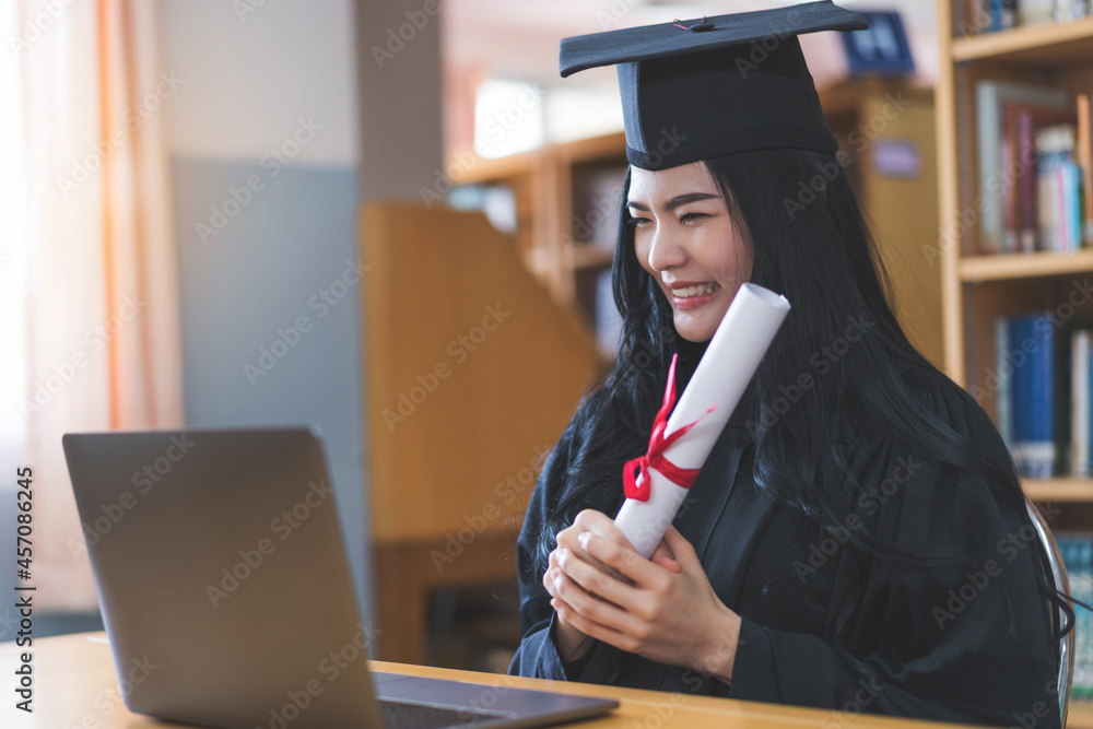 Poster University graduate in graduation gown and mortarboard celebrates in a virtual graduation ceremony. Happy female student on her graduation day at home. Concept of online education