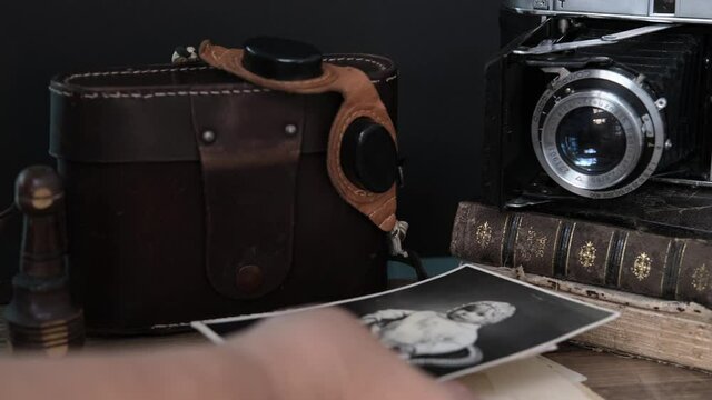 old family photos 50s, 60s, retro camera, books, glasses for solar eclipse on wooden table, concept of genealogy, memory of ancestors, family tree, childhood memories, home archive