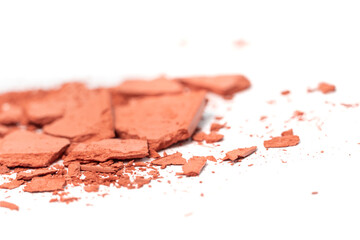 Creative photo of cosmetic swatches. Eye shadows in bronze colour broken on a white background 