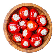 Small red cherry peppers stuffed with soft cheese in wooden bowl isolated on white background. Top...