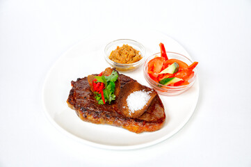 Grilled pork steak with croutons, salad, sauce and tomatoes.
