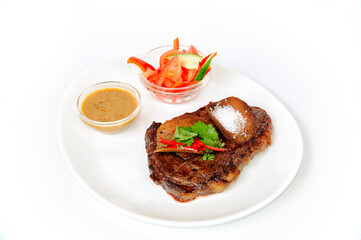 Grilled pork steak with croutons, salad, sauce and tomatoes.