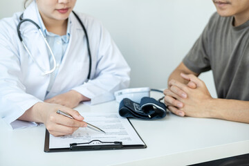 Doctor is pointing on document to explaining disease and illness symptoms for patient before writing