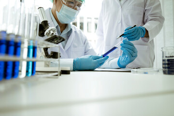 Scientists are holding chemical test tubes in a room