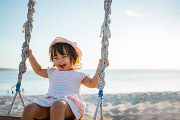 happy Little girl swinging at the beach