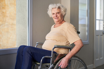 Elderly smiling woman in wheelchair after stroke