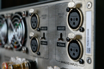 Obraz premium rear panel of the stereo amplifier. Audio electronics, connectors for cable connections. Mode switch. listen to good music, beautiful sound. Shallow depth of field, bokeh.