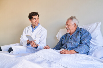 Male nurse shows senior patient the tablet computer