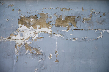 Old street wall. Cracked plaster, paint layers. Bad renovation, builder services. Background for the design of the site, album, book. Gray sadness. There is no perspective. Sad old age. 