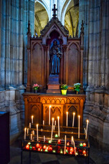 Pequeño altar de madera con velas encendidas en devoción a un santo en la catedral de Orleans,...