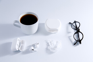 Isolated invisible aligner braces composed with laptop, coffee, and ear phones concept.