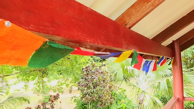 Close up slow motion shot of praying flags under the eaves.