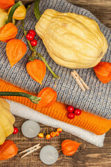 Autumn cozy composition. Ripe pumpkins, warm knitted sweaters, various berries, and candles