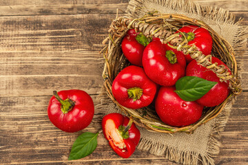 Ripe red round peppers in a handmade wicker basket
