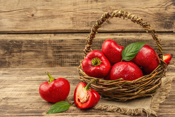 Ripe red round peppers in a handmade wicker basket