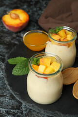 Concept of healthy food with peach yogurt on black smokey table