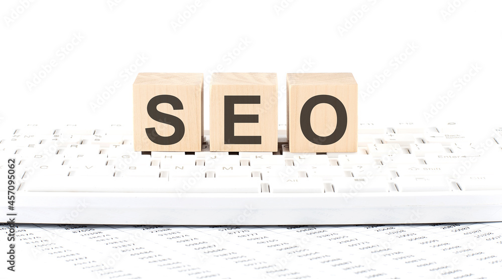 Poster seo -word wooden block on the keyboard background witn chart