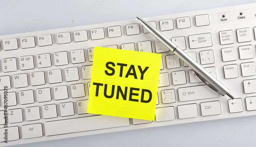 Poster text stay tuned on the keyboard on the white background