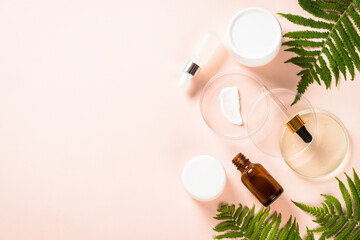 Cosmetic laboratory concept . Glass petri dish with natural cosmetic products and plants. Flat lay image.
