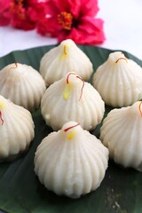 Steamed or ukdiche Modak. It's a traditional sweet dish made out of coconut, jaggery and dry fruits stuffed inside rice dough. Offered to Lord Ganesha during Ganpati festival in India. with copy space