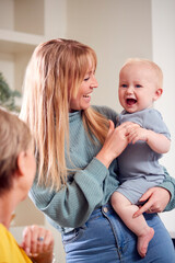 Grandmother With Adult Daughter And Baby Grandson At Home In Kitchen