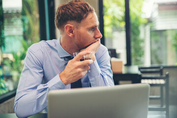 Stressed businessman, Frustrated and upset in business pressure, and overworked at office. Adult Caucasian male working on laptop, feeling tire and headache. Stressed and Frustrated concept.