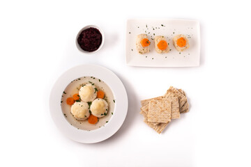 Traditional Jewish matzah ball soup, gefilte fish and matzah bread