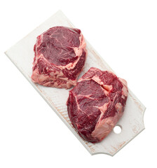 raw piece of beef ribeye with rosemary, thyme on a white background
