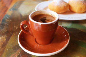 Cup of Hot Coffee with Blurry Fried Georgian Doughnuts in the Backdrop