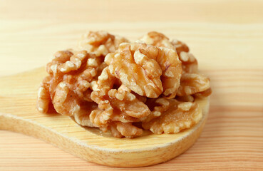 Pie of Walnut Kernels on a Wooden Spoon Isolated on Wooden Table