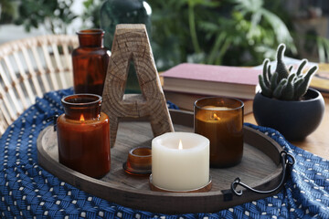 Wooden tray with decorations and houseplant on table indoors