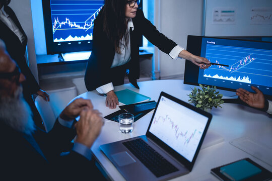 Multi generational trader team making stock market analysis conference inside hedge fund office - Focus on woman face