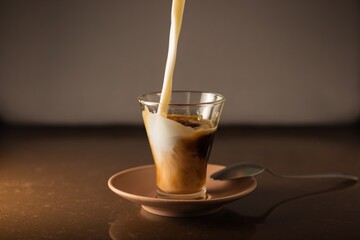 chorro de leche cae desde arriba entrando dentro de la taza de café para hacer café con leche con...