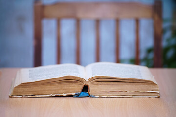 An open book on a wooden table. Selective focus
