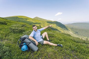 Naklejka na ściany i meble hiker high in the mountains. mountain tourism concept. hiking in the mountains. summer vacation