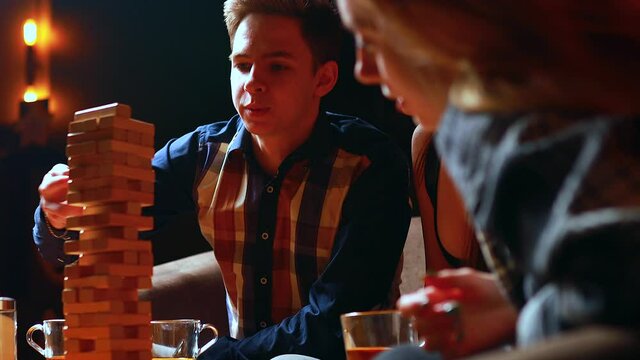 Authentic people Young people have fun playing board games at a table in cafe