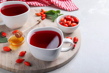 Obraz na płótnie Canvas Fresh rose hip tea and berries on light table