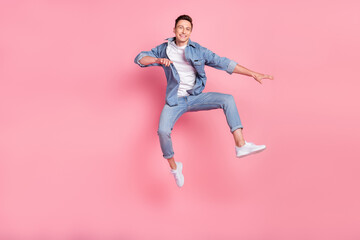 Fototapeta na wymiar Full size photo of young good looking smiling cheerful guy jumping freedom summertime isolated on pink color background