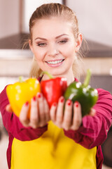 Happy woman holding bell peppers paprika