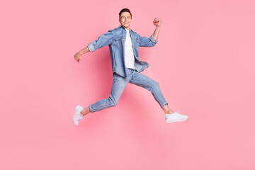 Fototapeta na wymiar Full size profile side photo of young handsome smiling guy running in air enjoy summer isolated on pink color background