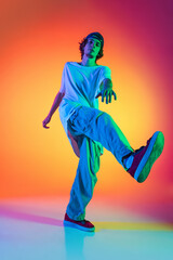 Close-up portrait of young man, hip-hop dancer in stylish clothes in action isolated on colorful...
