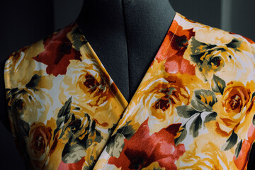 the collar of a yellow-red dress made of natural fabric on a mannequin. close-up photo of clothes. smooth seams and stitches are stitched with thread. the seamstress makes individual tailoring at home