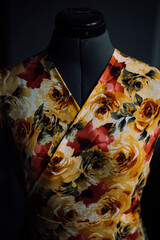 the collar of a yellow-red dress made of natural fabric on a mannequin. close-up photo of clothes. smooth seams and stitches are stitched with thread. the seamstress makes individual tailoring at home