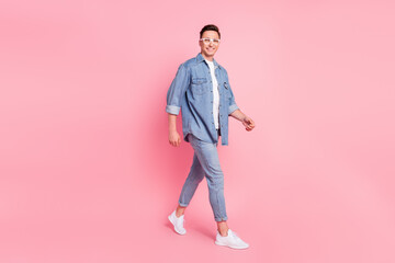 Full size photo of smiling positive good mood male go walk wear spectacles summertime isolated on...